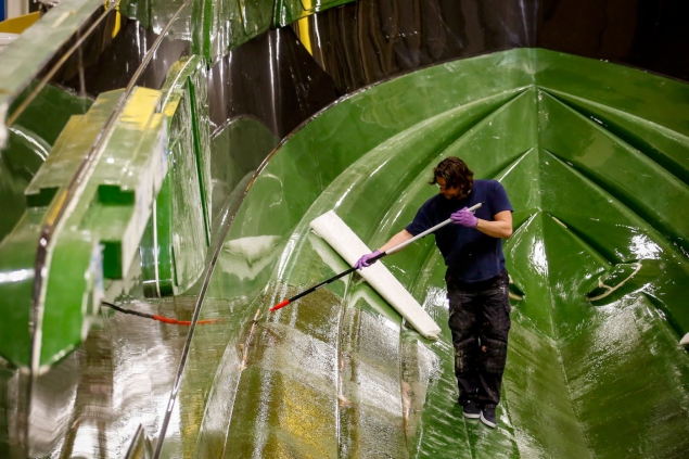 An employee works on a hull in the large moulds unit.
Photographer: Luke MacGregor/Bloomberg