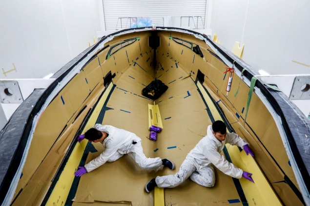 Employees construct the hull of an R35 yacht.
Photographer: Luke MacGregor/Bloomberg